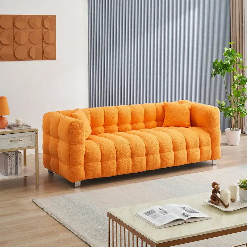 Canapé trois places orange avec deux coussins et des pieds en métal robustes